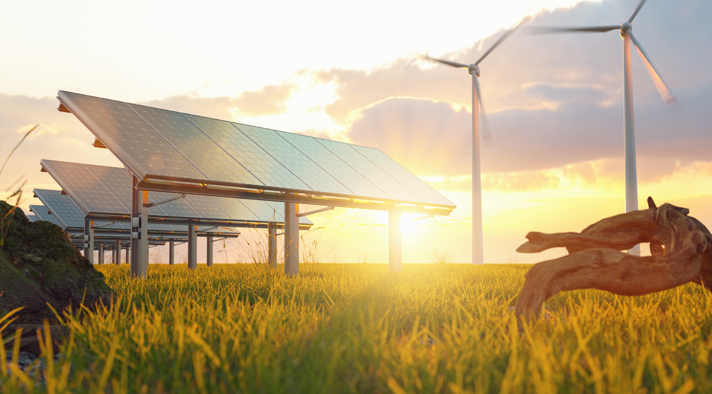 Solceller og vindmøller i solned/opgang i naturen